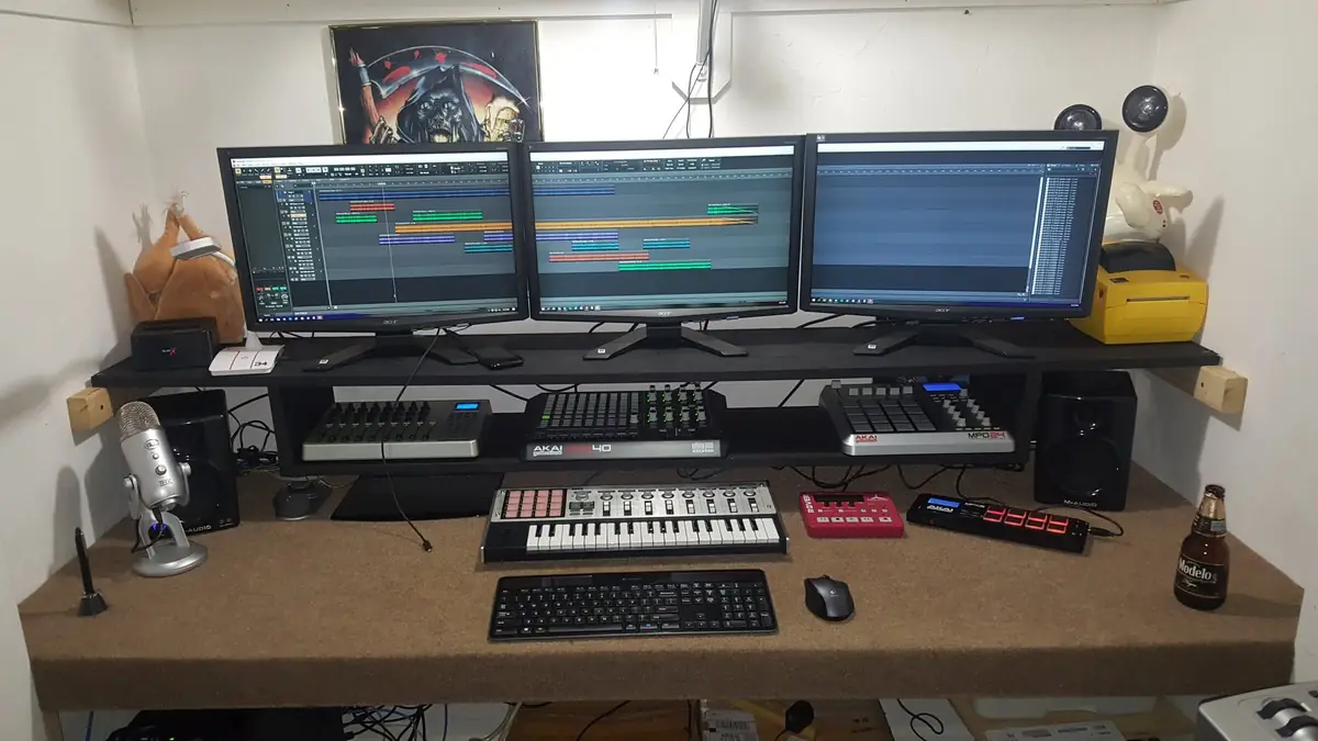 The golden-age command desk: triple monitors running the DAW, controllers and studio speakers, around 2019