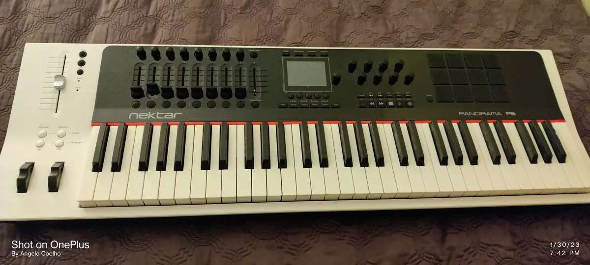 Cream-bodied vintage polysynth with a bank of sliders, small LCD and red accent line above the keys