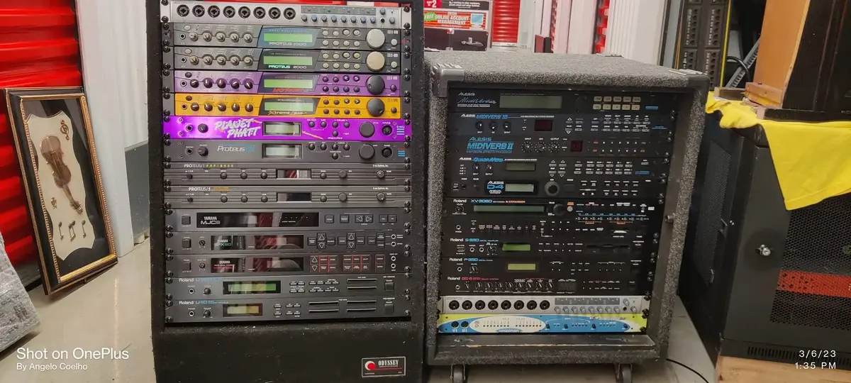 Open studio rack of outboard gear with knobs, patch bays and glowing multicolored LEDs