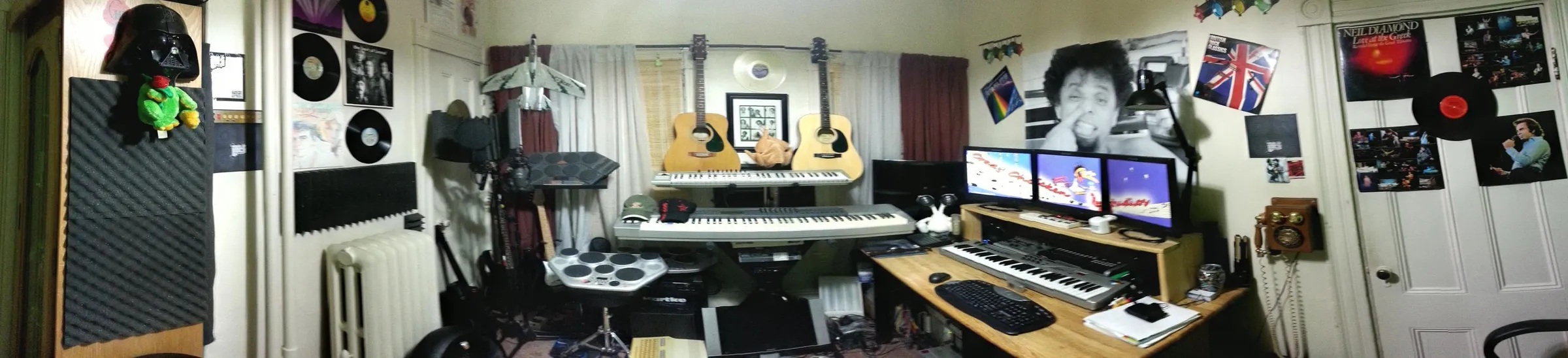 Panoramic view of the very first Crazy Chicken Studios setup back in 2013: keyboards, guitars, drum pads, microphone and a triple-monitor workstation surrounded by vinyl records and rock posters